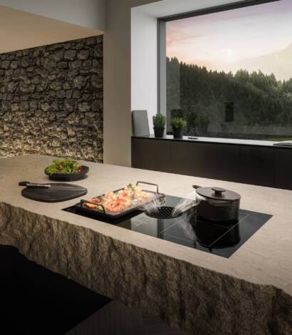 kitchen counter with cook top and window in the back