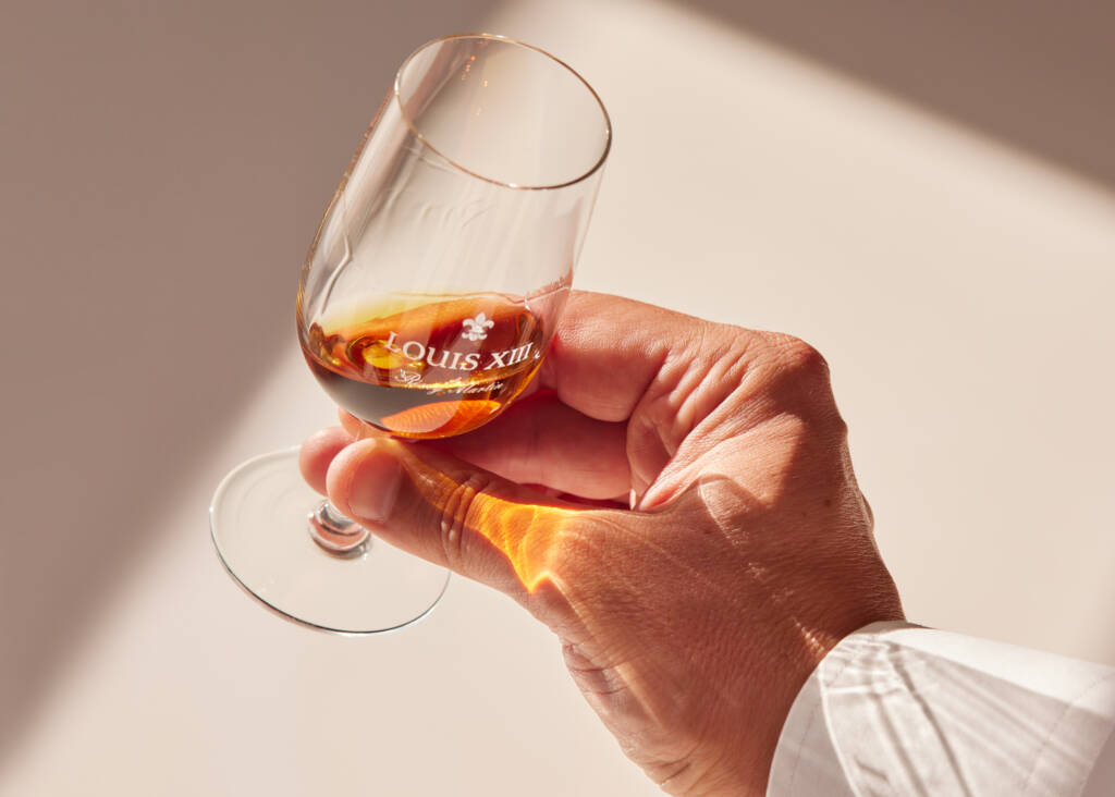 hand holding a small cognac glass