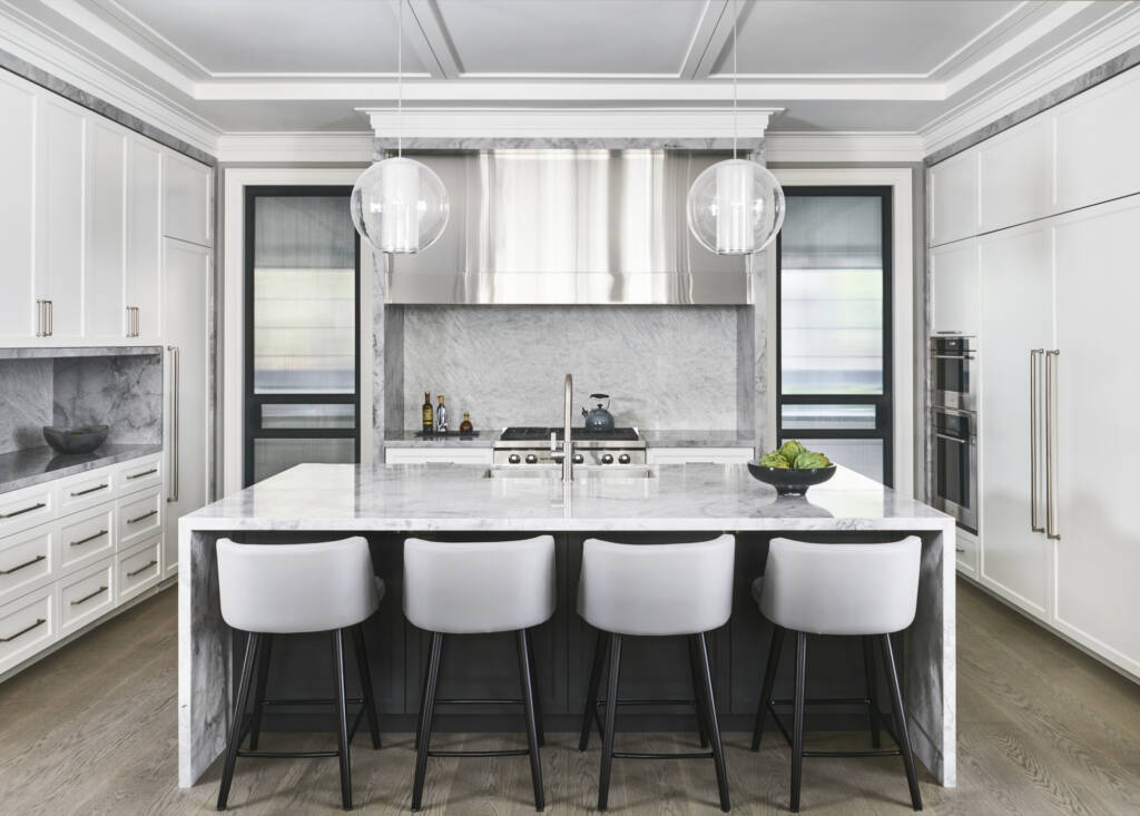 kitchen view with marble counter top, white high  chair, stainless steel stove, white cabinets