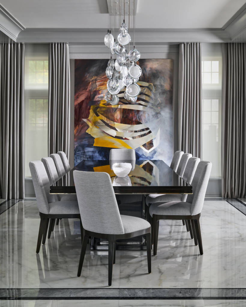 dinning room with marble floor, black dining table, grey chairs, colourful big painting on the back wall