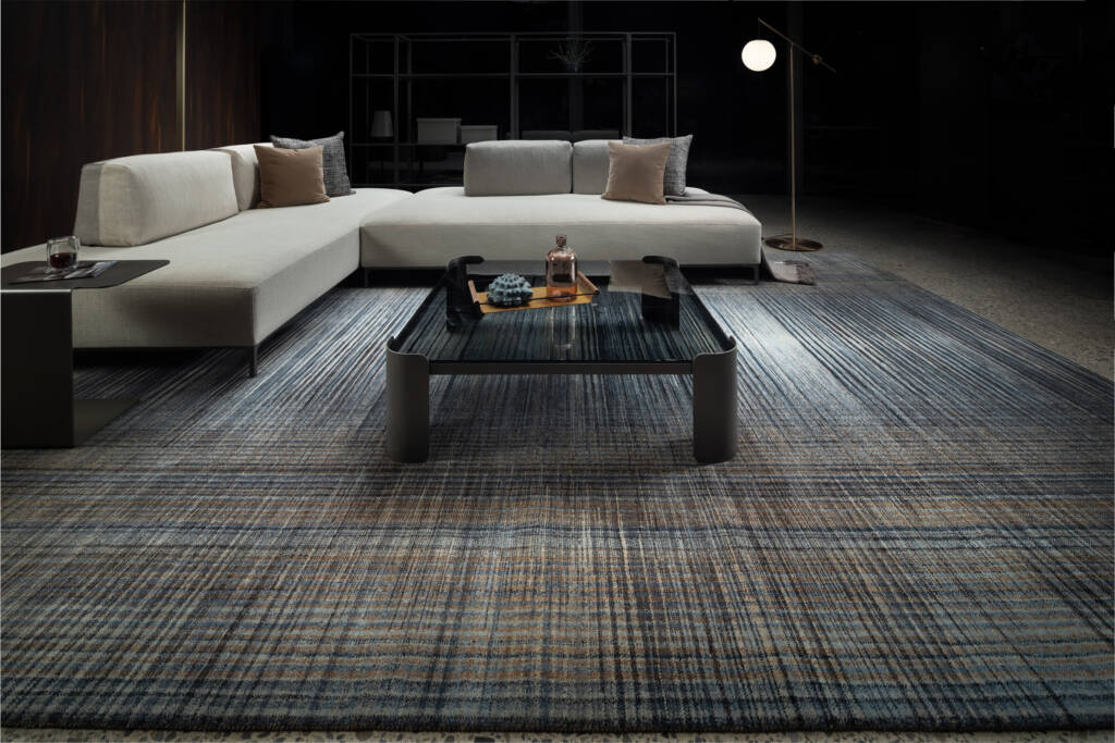 white sofa and glass table on top of grey and white rug