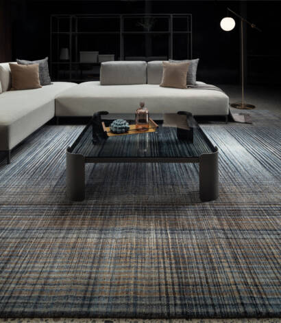 white sofa and glass table on top of grey and white rug